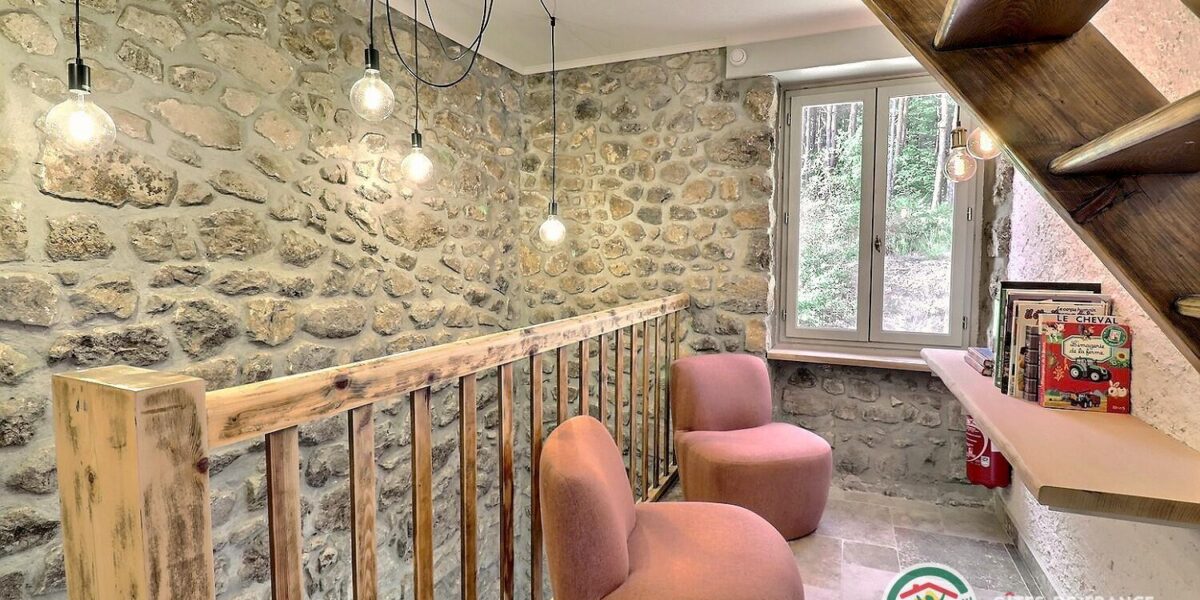 470844-21_309700_cca1ee2bf18f068302c4216b45090046 Mezzanine du gîte avec fauteuils, bibliothèque et mur de pierre apparente