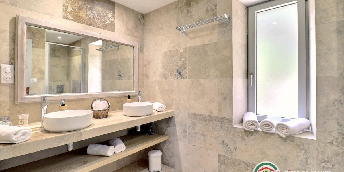 470844-14_309700_5b5cff6240d15e99616272ea5725ee24 Salle d’eau du gîte avec double vasque, grand miroir et carrelage clair