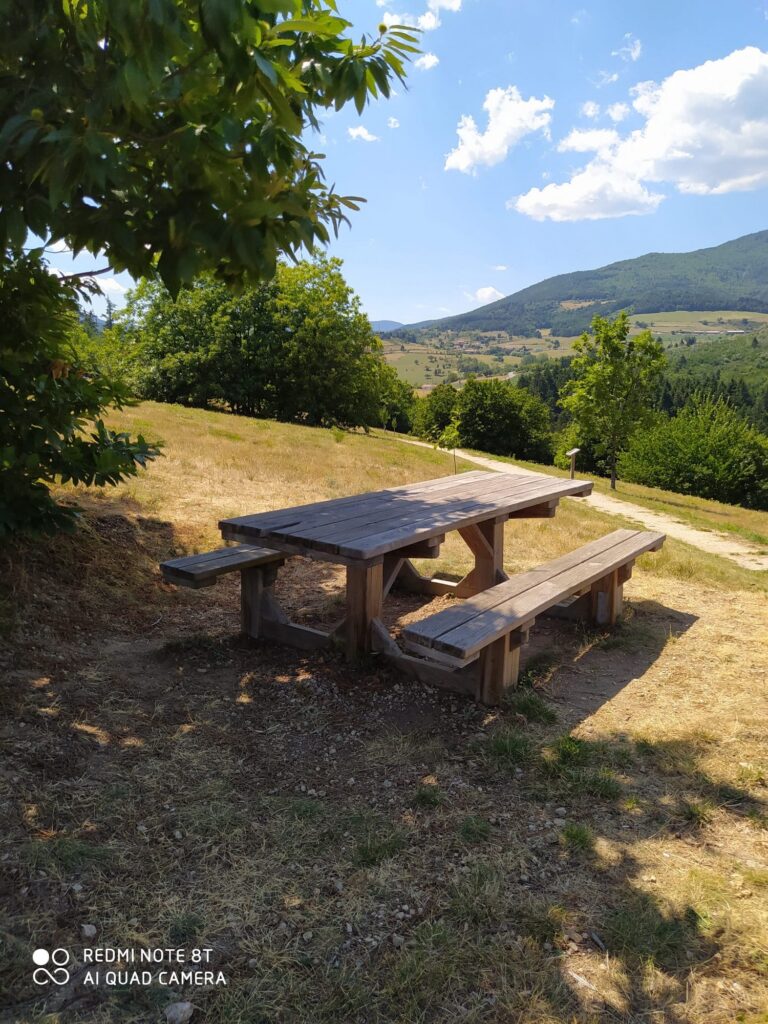 Table de pique-nique en bois installée en hauteur, face aux collines de l’Ardèche verte